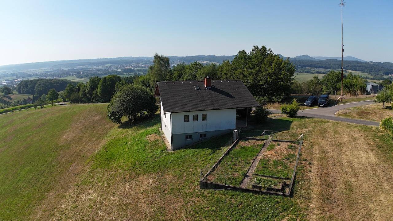 Luftaufnahme des Hauses mit weitem Blick über die umliegende Landschaft bis zur Stadt.