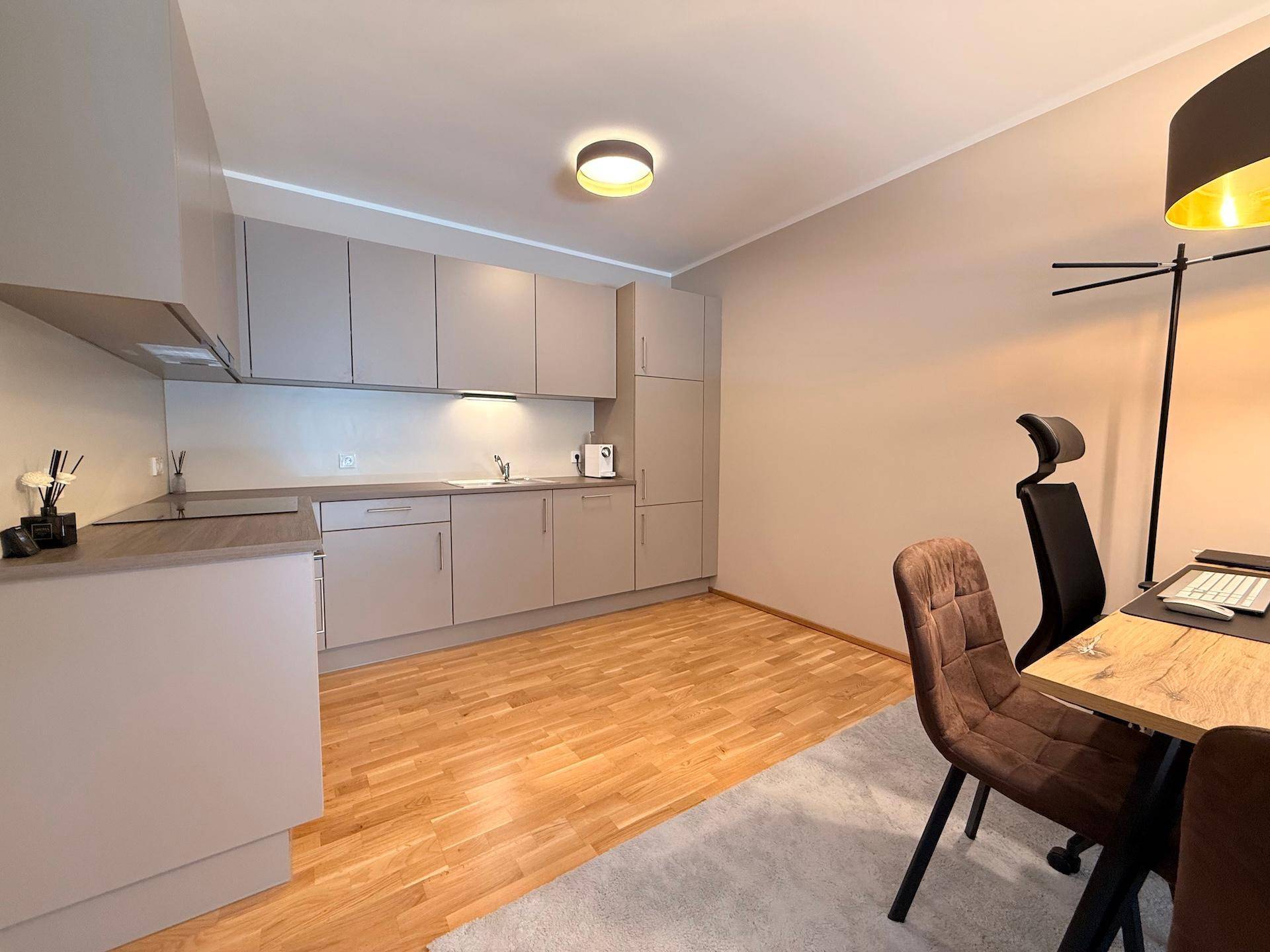 Moderne Einbauküche in Grau mit Holz-Arbeitsplatte und integriertem Essbereich.