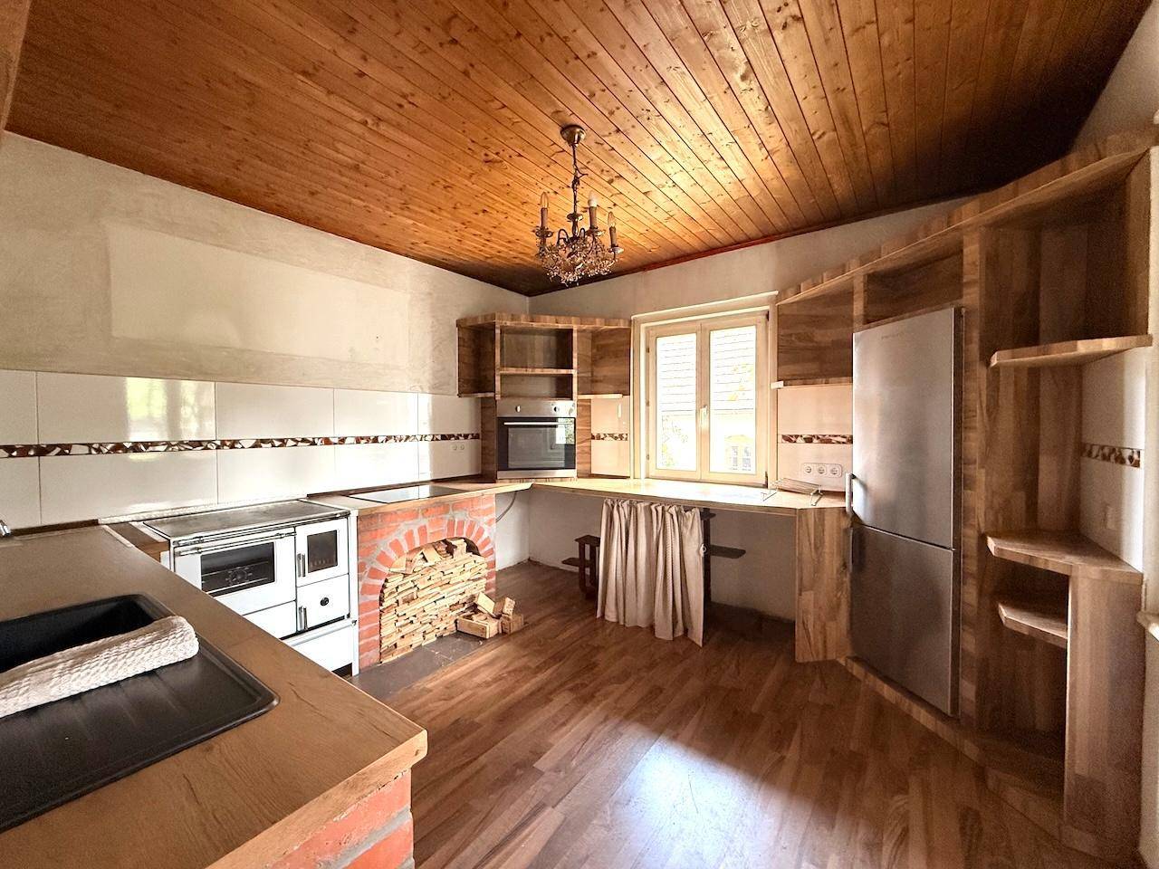 Rustikale Küche mit Holzdecke, Einbauherd und gemauertem Unterbau im Landhausstil.