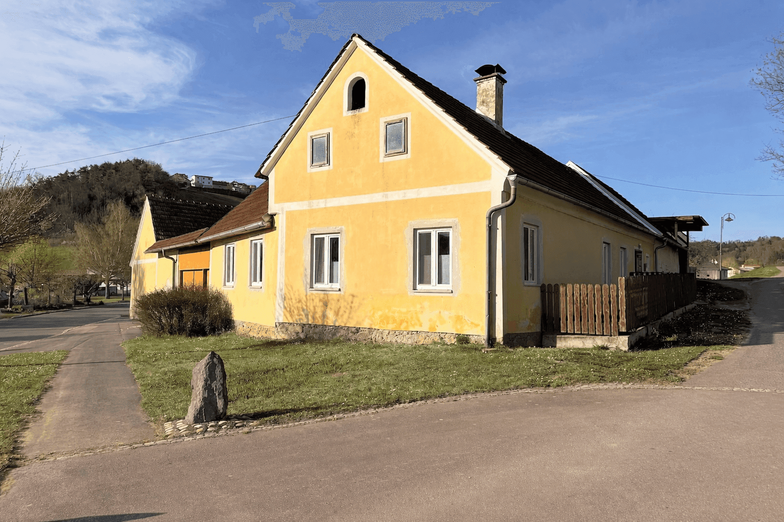 Charmantes gelbes Landhaus mit traditioneller Architektur und rotem Ziegeldach in sonniger Lage.