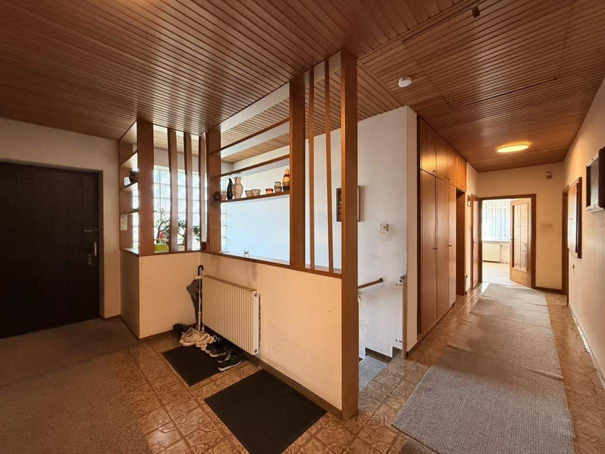 Geräumiger Flur mit Holzvertäfelung, integrierten Schränken und einem Heizkörper an der Wand.