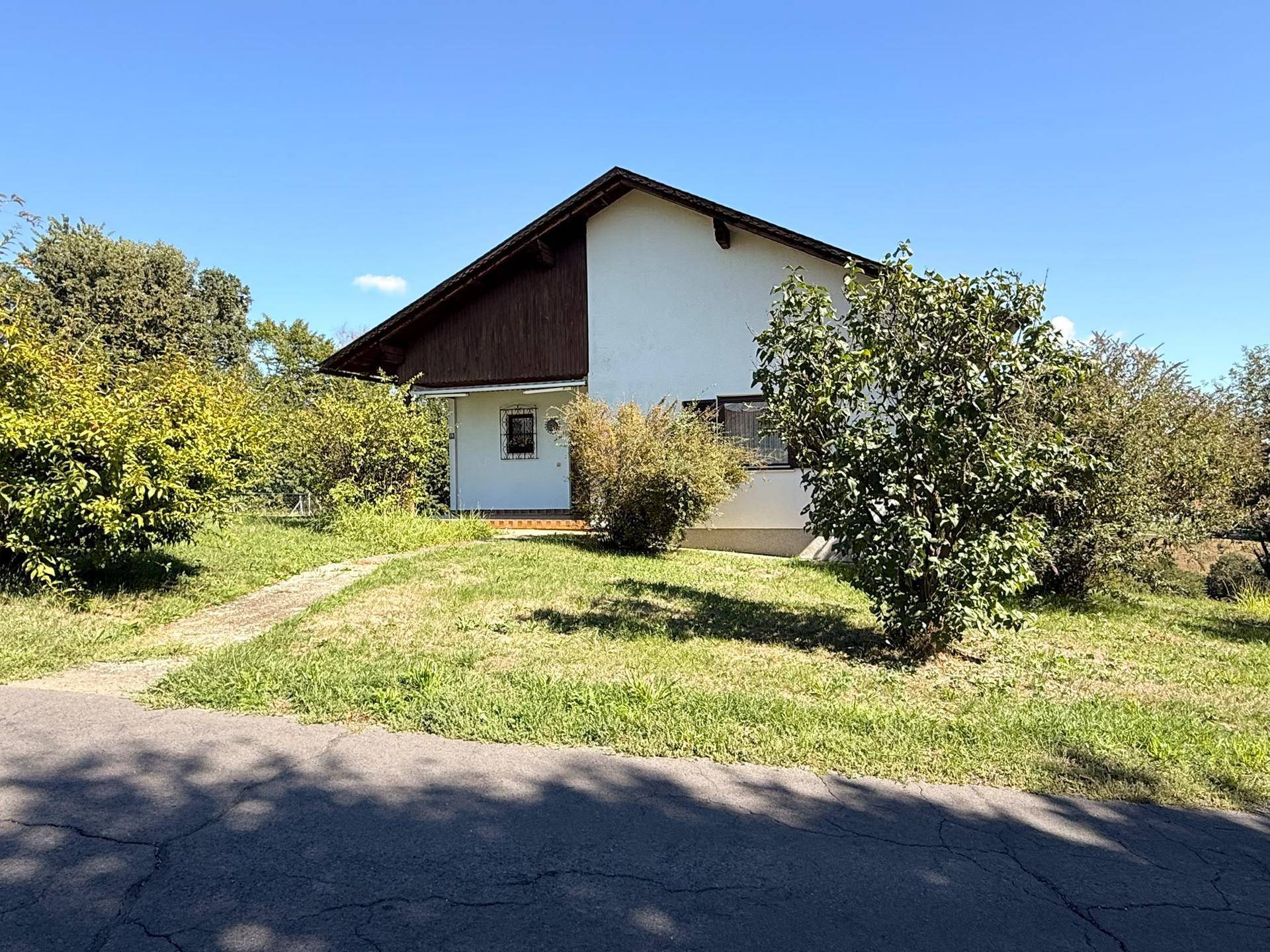 Vorderansicht des Einfamilienhauses mit gepflegtem Vorgarten und Zugangsweg an einem sonnigen Tag.