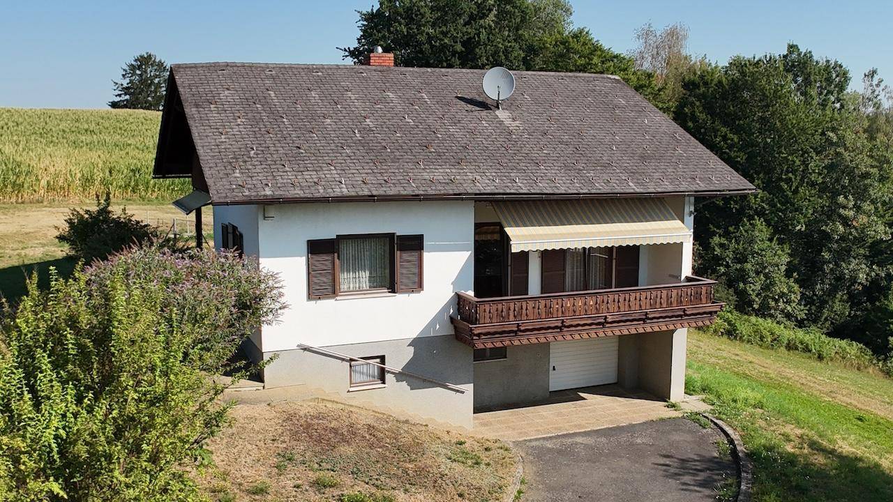 Nahaufnahme aus der Luft des Hauses, das den Balkon und die Garage in ländlicher Umgebung zeigt.