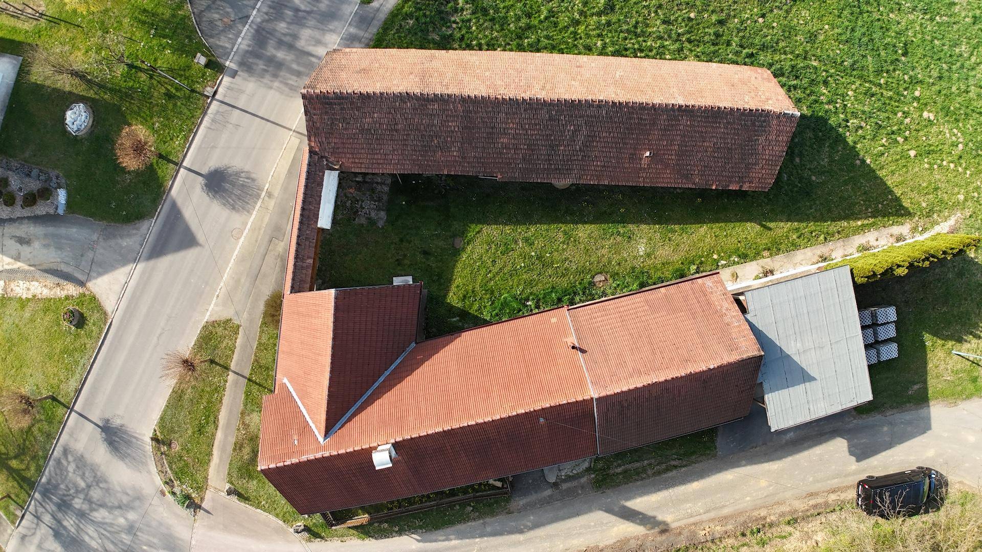 Luftaufnahme des Anwesens mit mehreren Gebäuden und weitläufigen Grünflächen in ländlicher Umgebung.