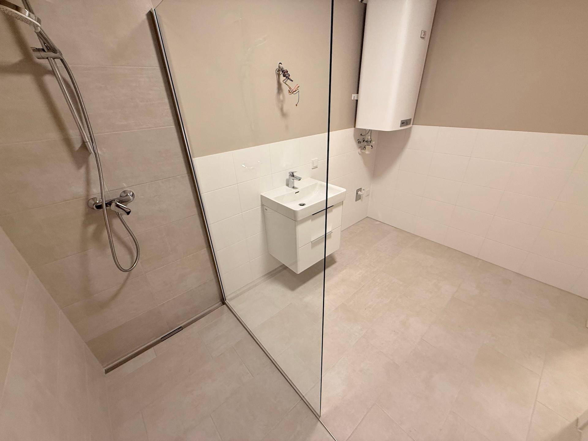 Modernes Badezimmer mit ebenerdiger Dusche, Waschbecken und Warmwasserboiler.