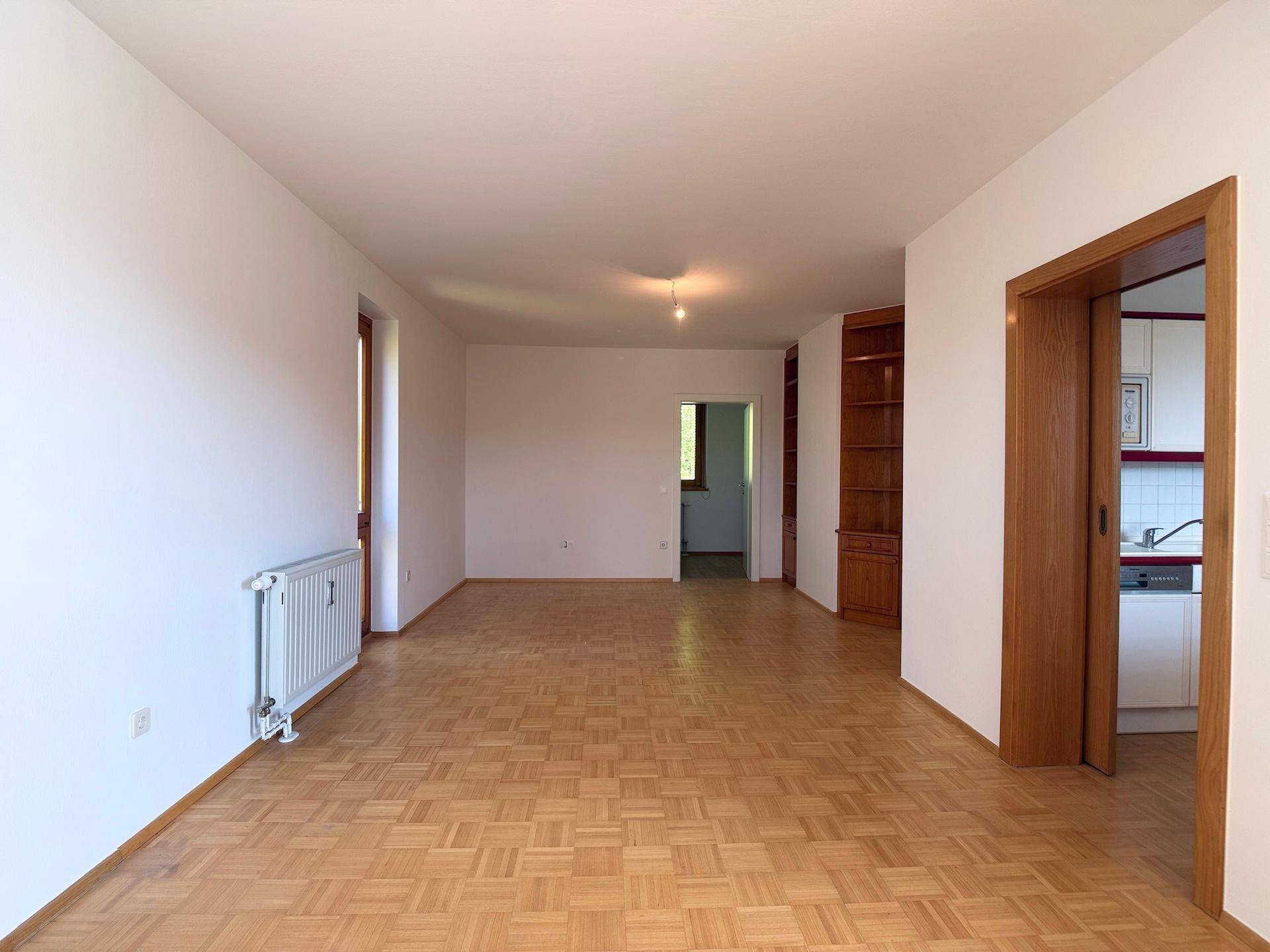 Großzügiges Wohnzimmer mit klassischem Parkettboden und viel Potenzial zur individuellen Gestaltung.