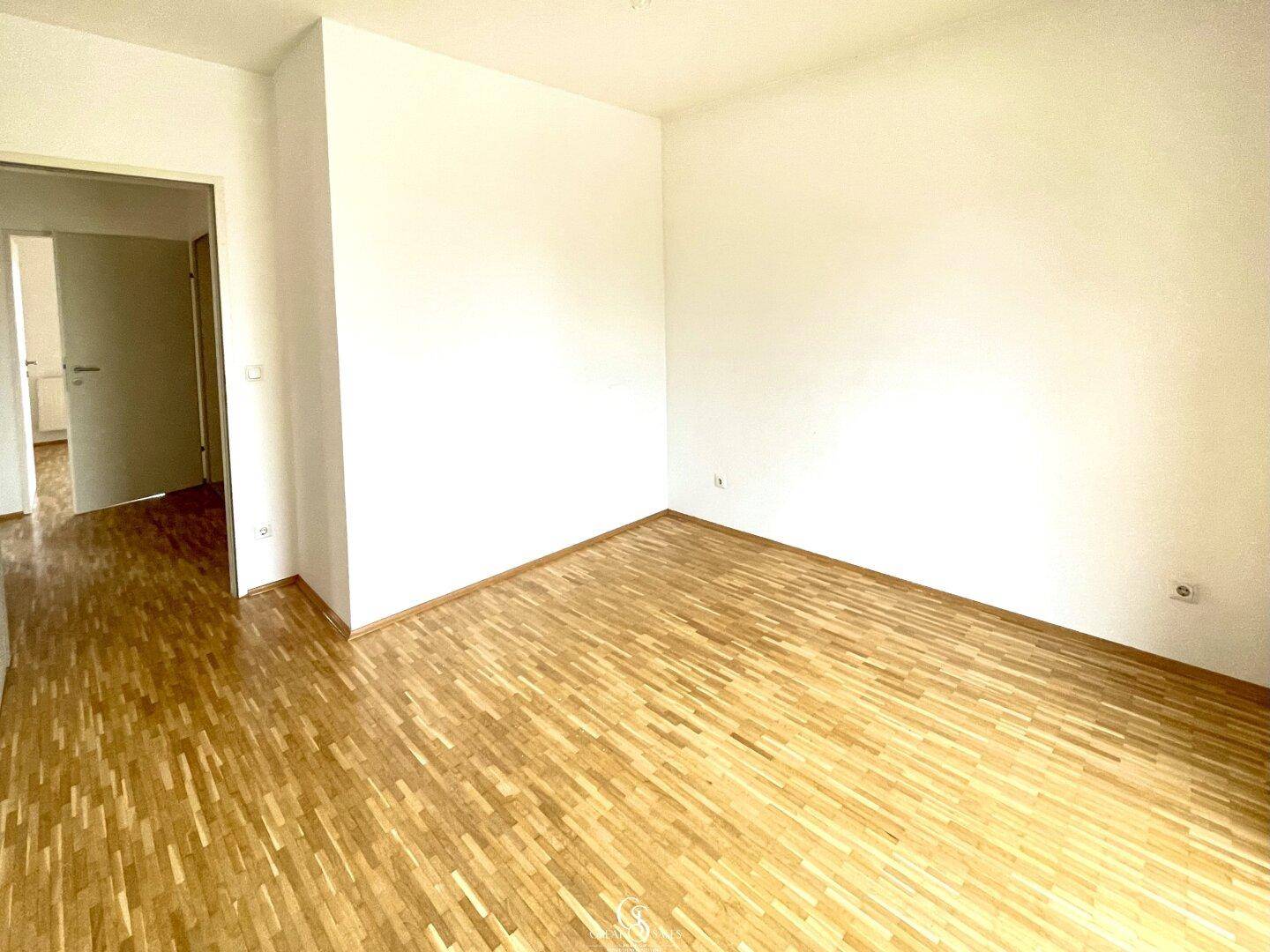 Geräumiges Schlafzimmer mit Parkettboden und weiß gestrichenen Wänden, bereit zur Einrichtung.