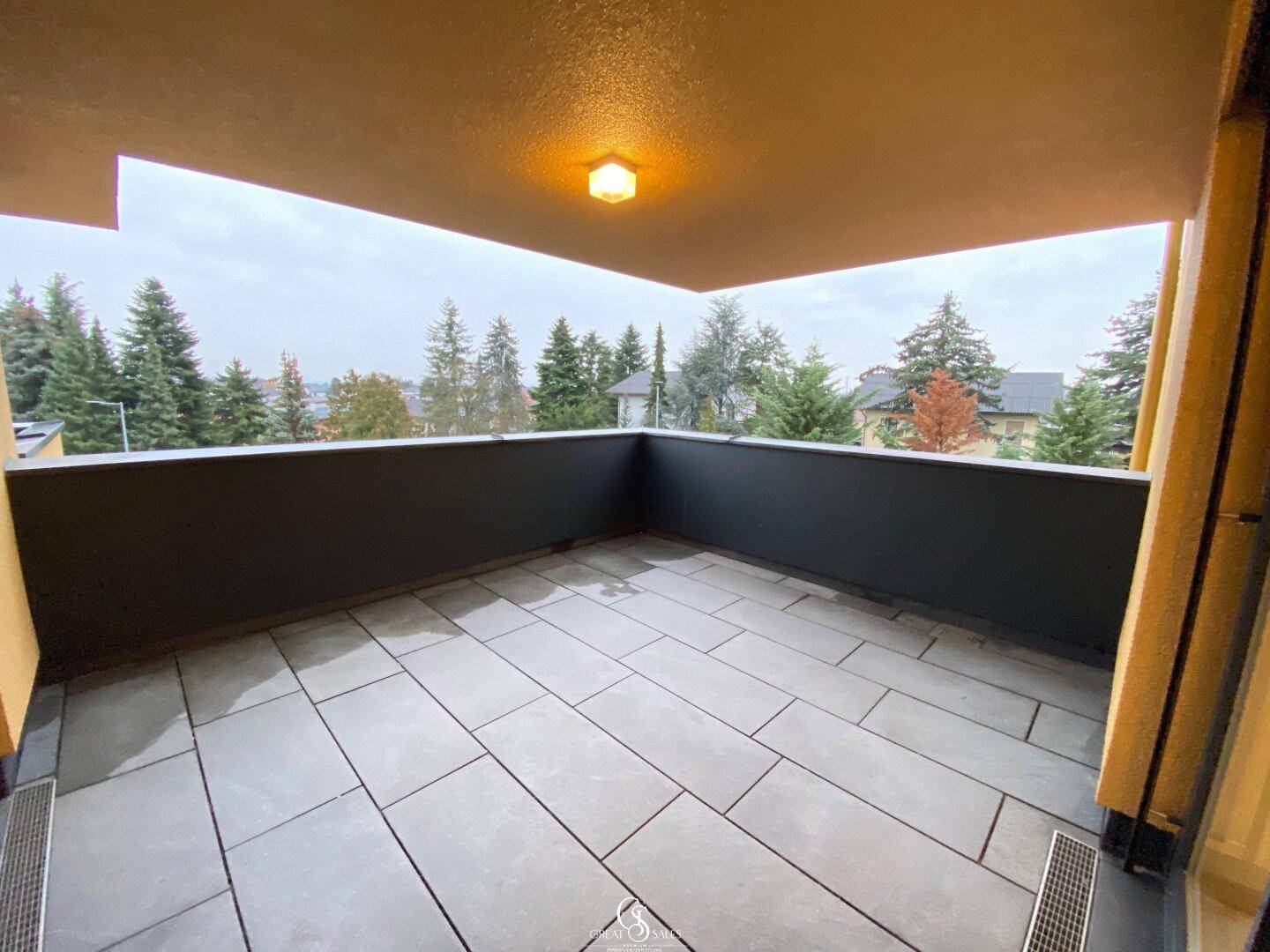 Geräumiger Balkon mit Fliesenboden und Blick ins Grüne, ideal für Entspannung im Freien.