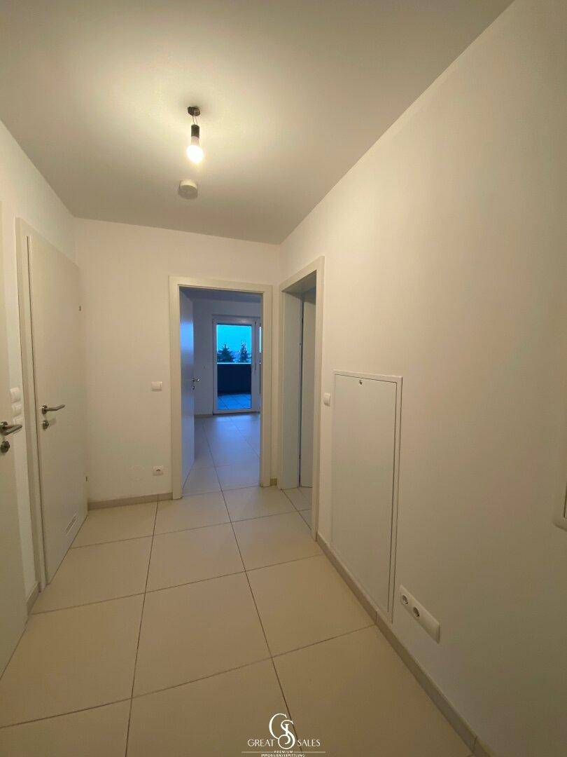 Heller Flur mit Fliesenboden und Zugang zu verschiedenen Räumen der Wohnung.