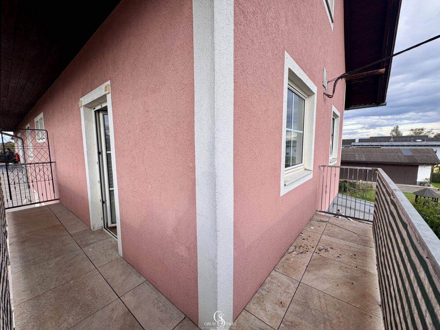 Langer Balkon mit Fliesenboden und einem weiten Blick auf die ländliche Umgebung.