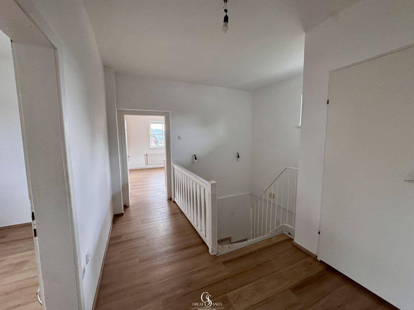 Heller Flur mit Treppenaufgang und Zugang zu weiteren Räumen im Obergeschoss des Hauses.