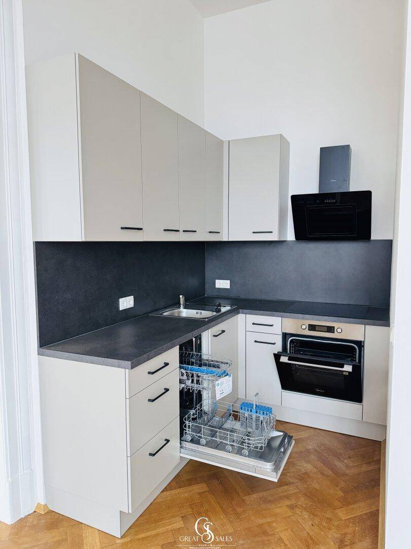 Kompakte Einbauküche mit Geschirrspüler, Backofen und Dunstabzugshaube, in hellem Design.
