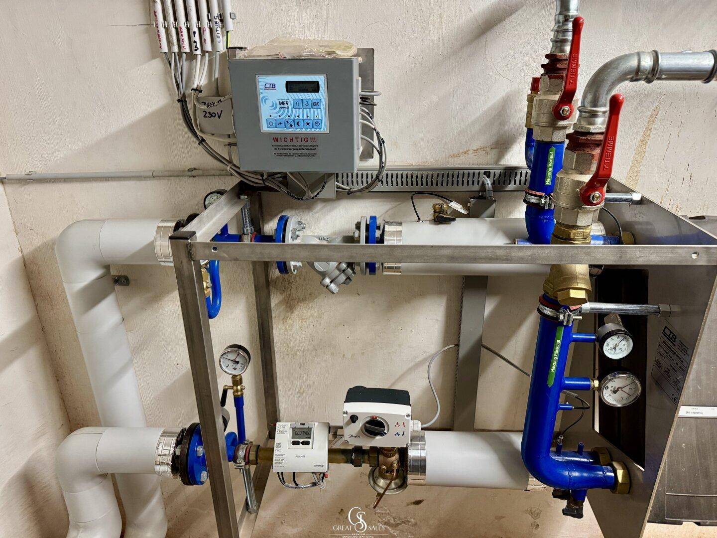 Detailansicht der Heizungsanlage mit Ventilen, Rohren und Steuerungselementen in einem Technikraum.