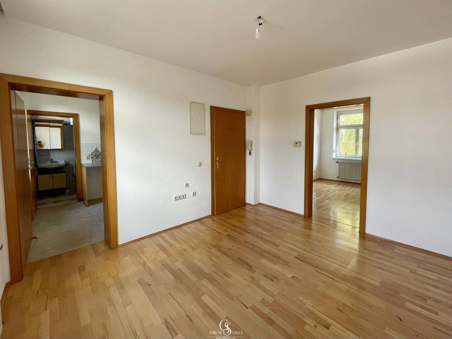 Heller Flur mit Holzparkettboden und Türen zu verschiedenen Zimmern der Wohnung.
