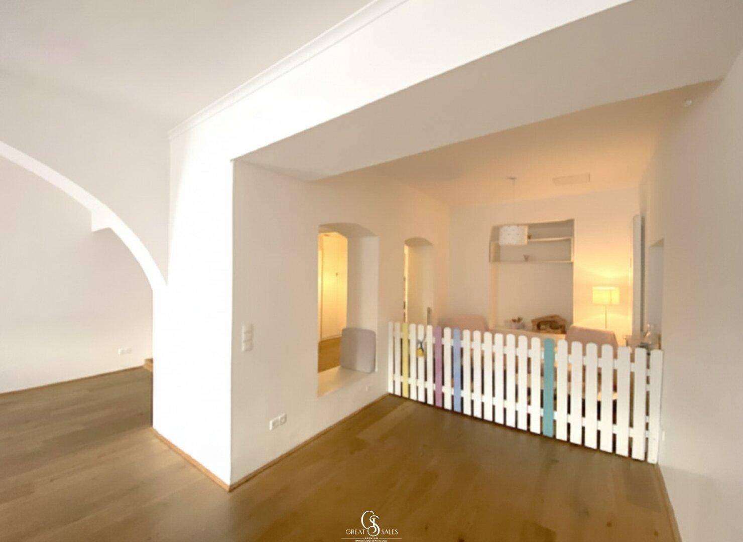 Heller Bereich mit einem kleinen bunten Zaun und einer gemütlichen Fensternische.