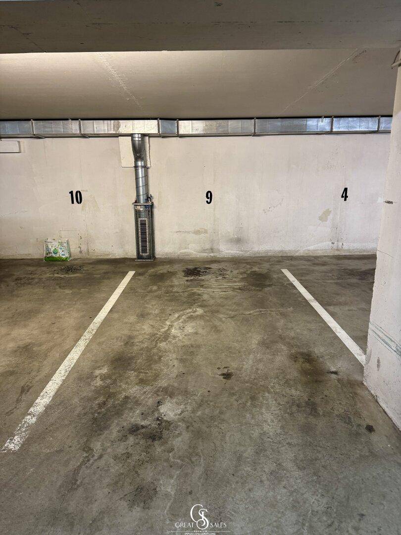 Tiefgaragenstellplatz mit Betonboden und Nummerierung, bietet sicheren Parkraum.