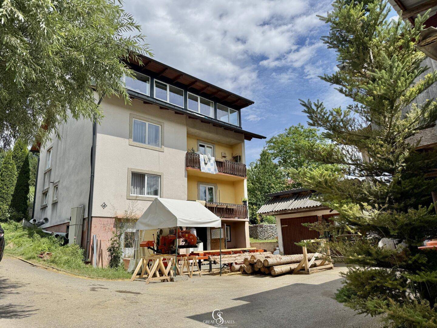 Mehrstöckiges Gebäude mit Balkonen und einem Arbeitsbereich im Freien.