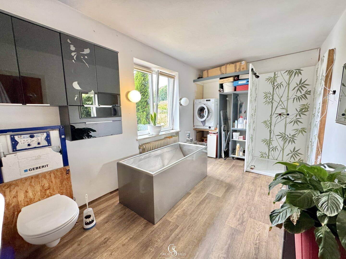 Geräumiges Badezimmer mit freistehender Badewanne, Toilette und Duschbereich.