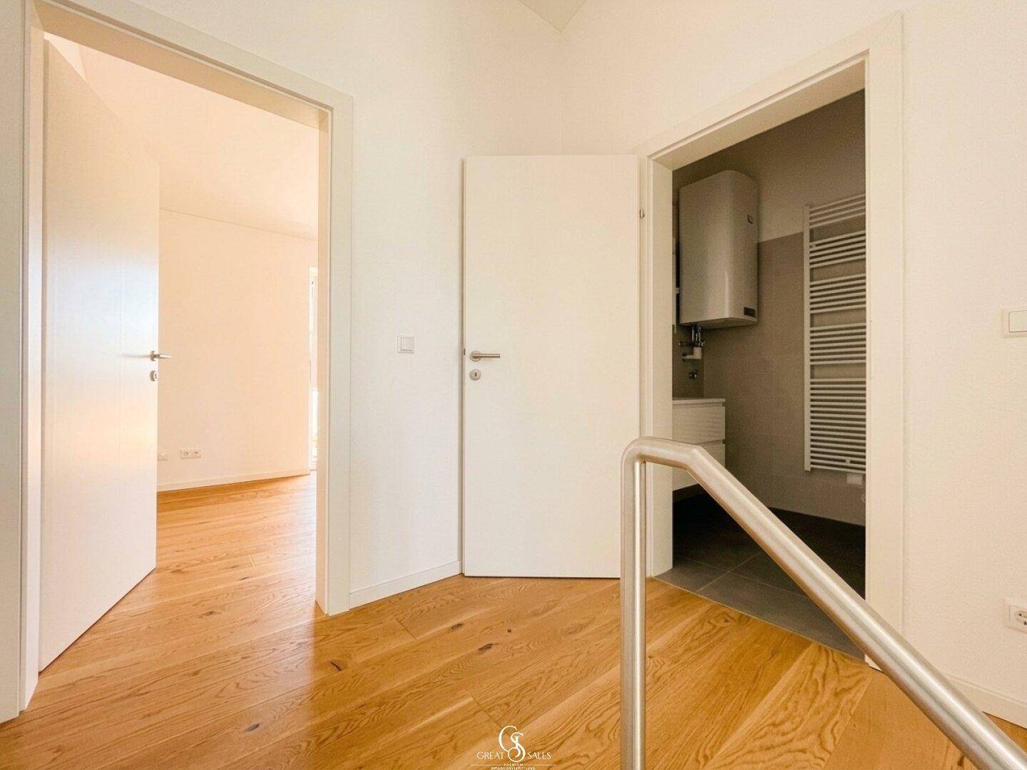 Heller Flur im Obergeschoss mit Holzboden und Zugang zu weiteren Zimmern und Bad.