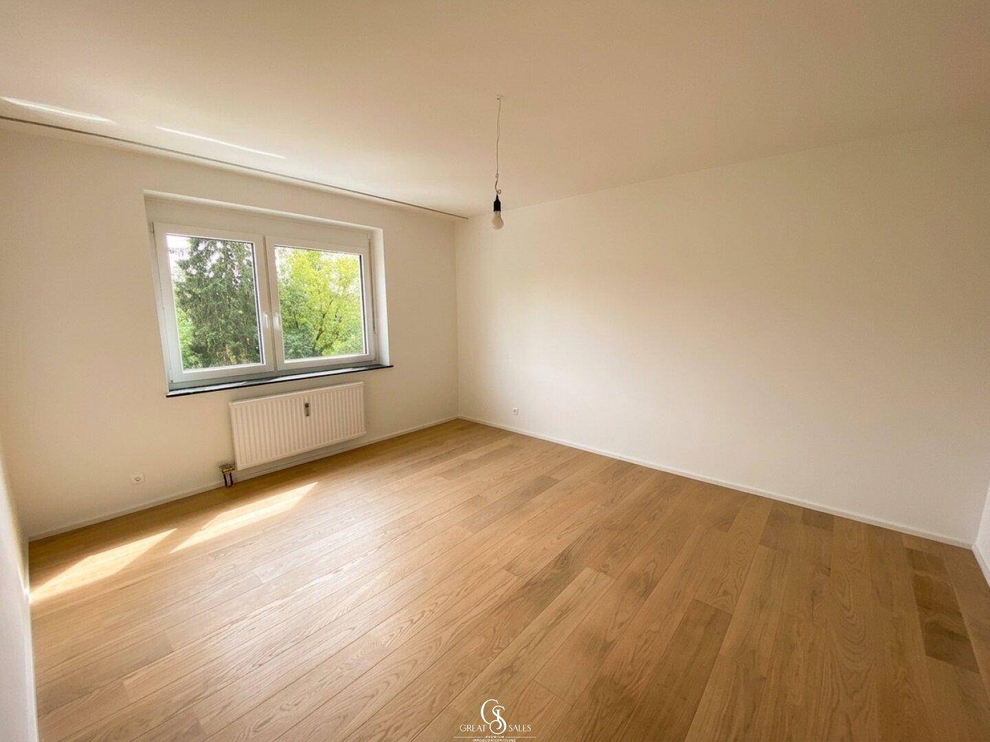 Helles- und großzügiges Schlafzimmer mit Blick ins Grüne