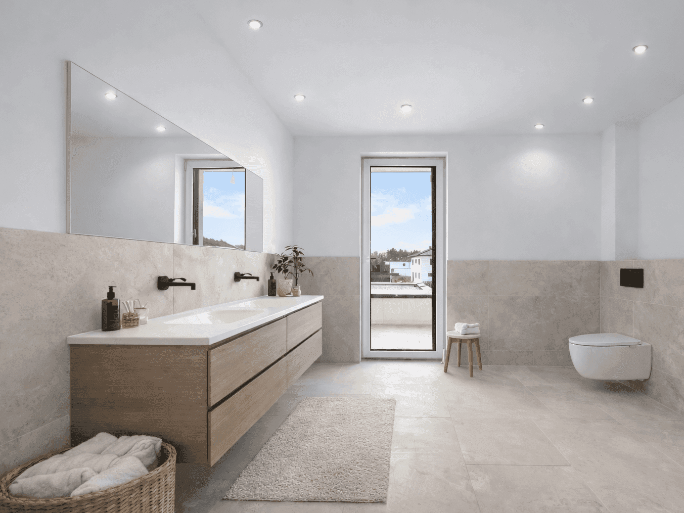 Modernes Badezimmer mit Doppelwaschbecken, großem Spiegel und Zugang zu einem Balkon.