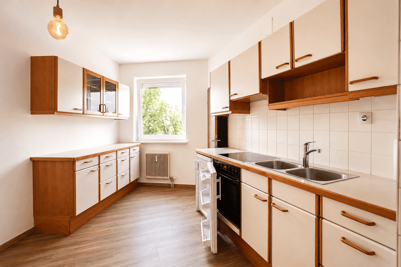 Geräumige Küche mit Einbauküche, Fenster und hellem Laminatboden, bereit zur individuellen Gestaltung.