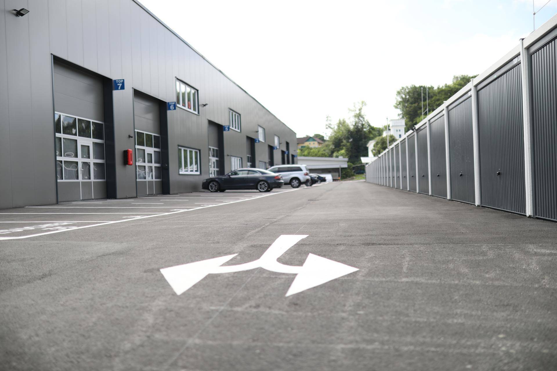 Außenansicht eines modernen Gewerbegebäudes mit Parkplätzen und einer Reihe von Lagerboxen.