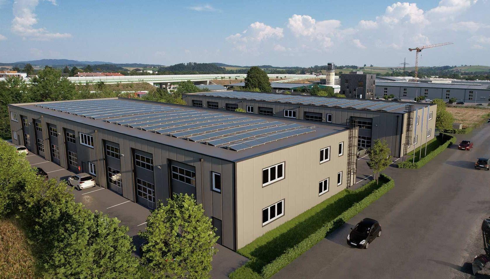 Luftaufnahme eines modernen Geschäftsgebäudes mit Photovoltaikanlage auf dem Dach und umliegenden Parkplätzen.