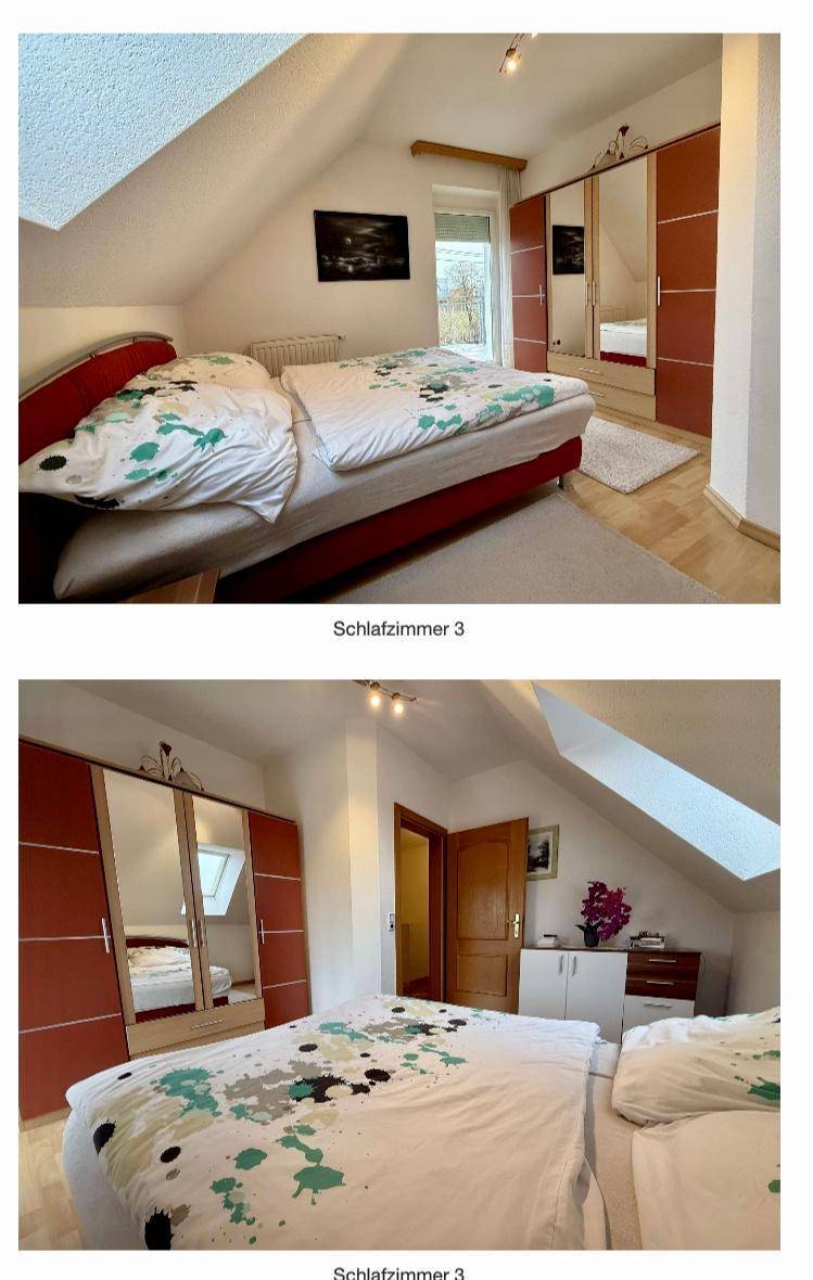 Dachschlafzimmer mit schrägen Wänden, Holzboden und Spiegelschränken.