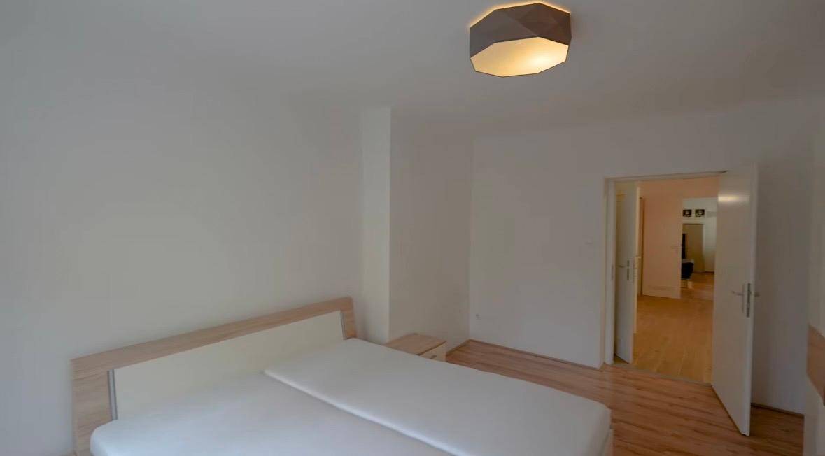 Gemütliches Schlafzimmer mit Doppelbett und Zugang zu einem weiteren Raum, hell und einladend.