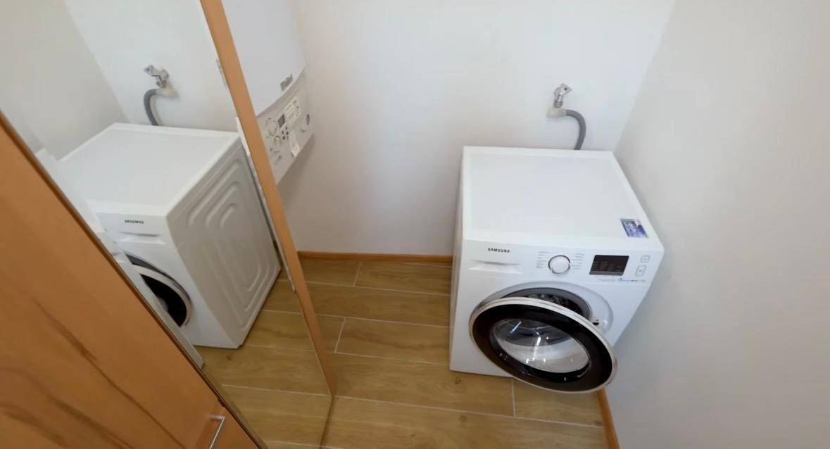 Praktischer Hauswirtschaftsraum mit Waschmaschine und Warmwasserbereiter, ideal für den täglichen Gebrauch.