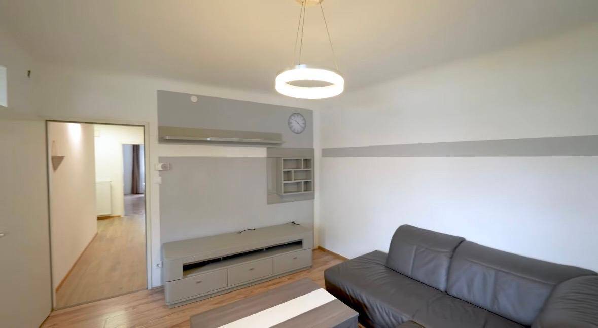 Modern eingerichtetes Wohnzimmer mit Medienschrank, Wandregalen und gemütlicher Eckcouch.