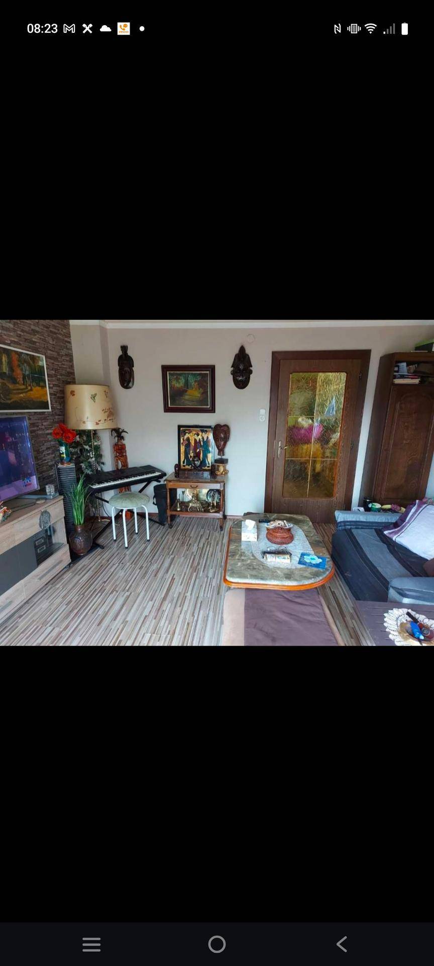 Wohnzimmer mit Holzboden, Couchtisch und vielfältiger Dekoration, schafft eine persönliche Atmosphäre.