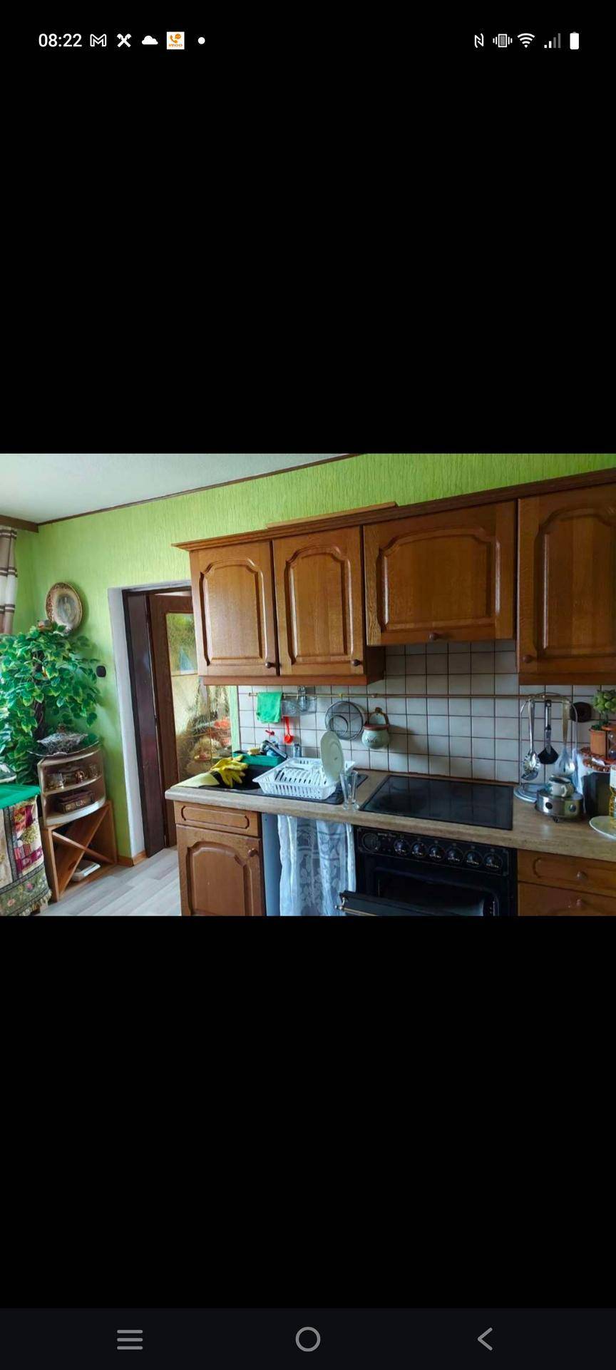 Traditionelle Küche mit Holzschränken, grünen Wänden und gefliestem Spritzschutz.