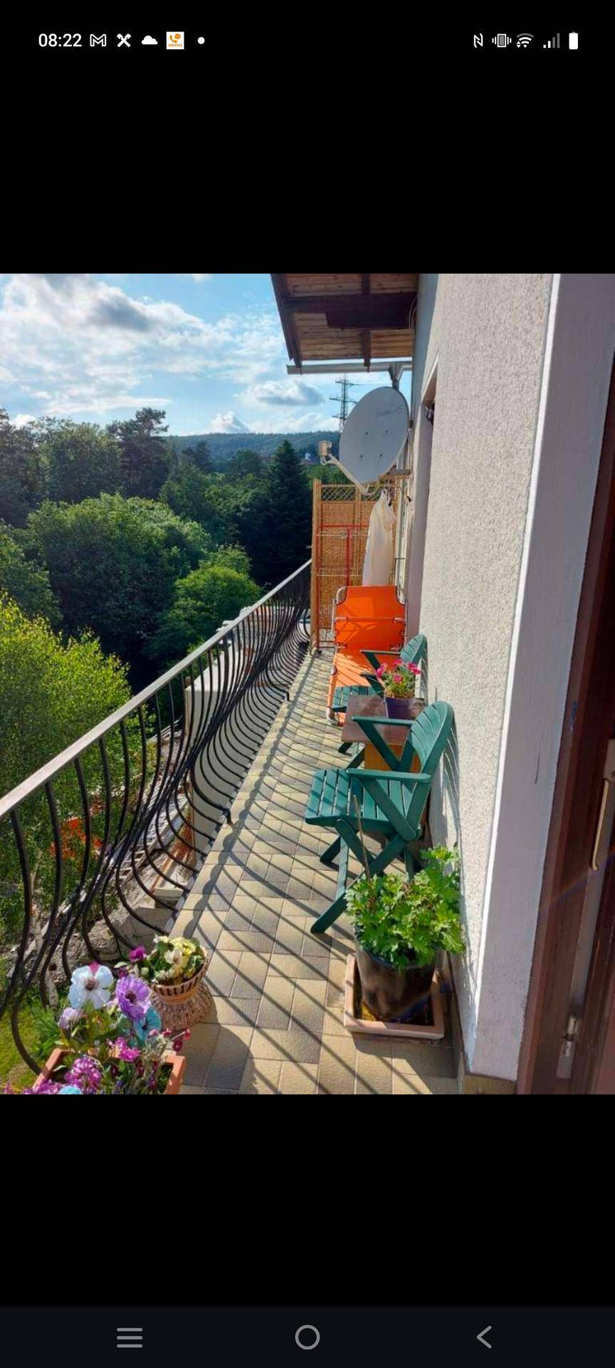 Balkon mit schmiedeeisernem Geländer, Sitzgelegenheiten und einem weiten, grünen Ausblick.