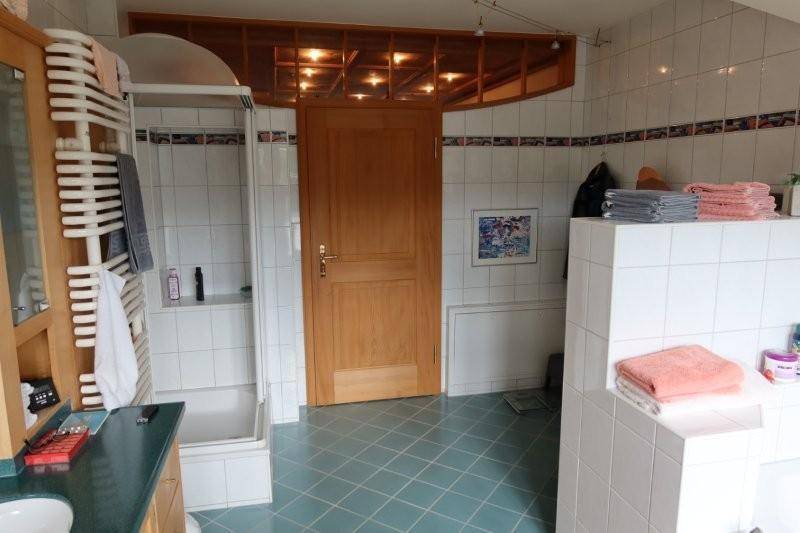 Badezimmer mit blauen Bodenfliesen, weißen Wandfliesen und einer Duschkabine.