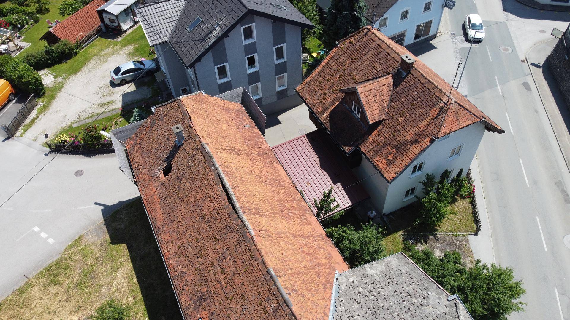 Luftaufnahme des Anwesens mit mehreren Gebäuden und Dächern in ländlicher Umgebung.