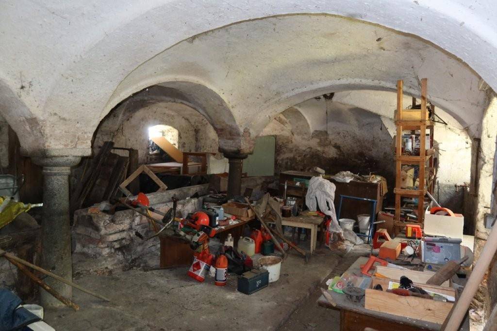 Historischer Gewölbekeller mit Steinmauern und Lagerfläche, der Renovierung benötigt.
