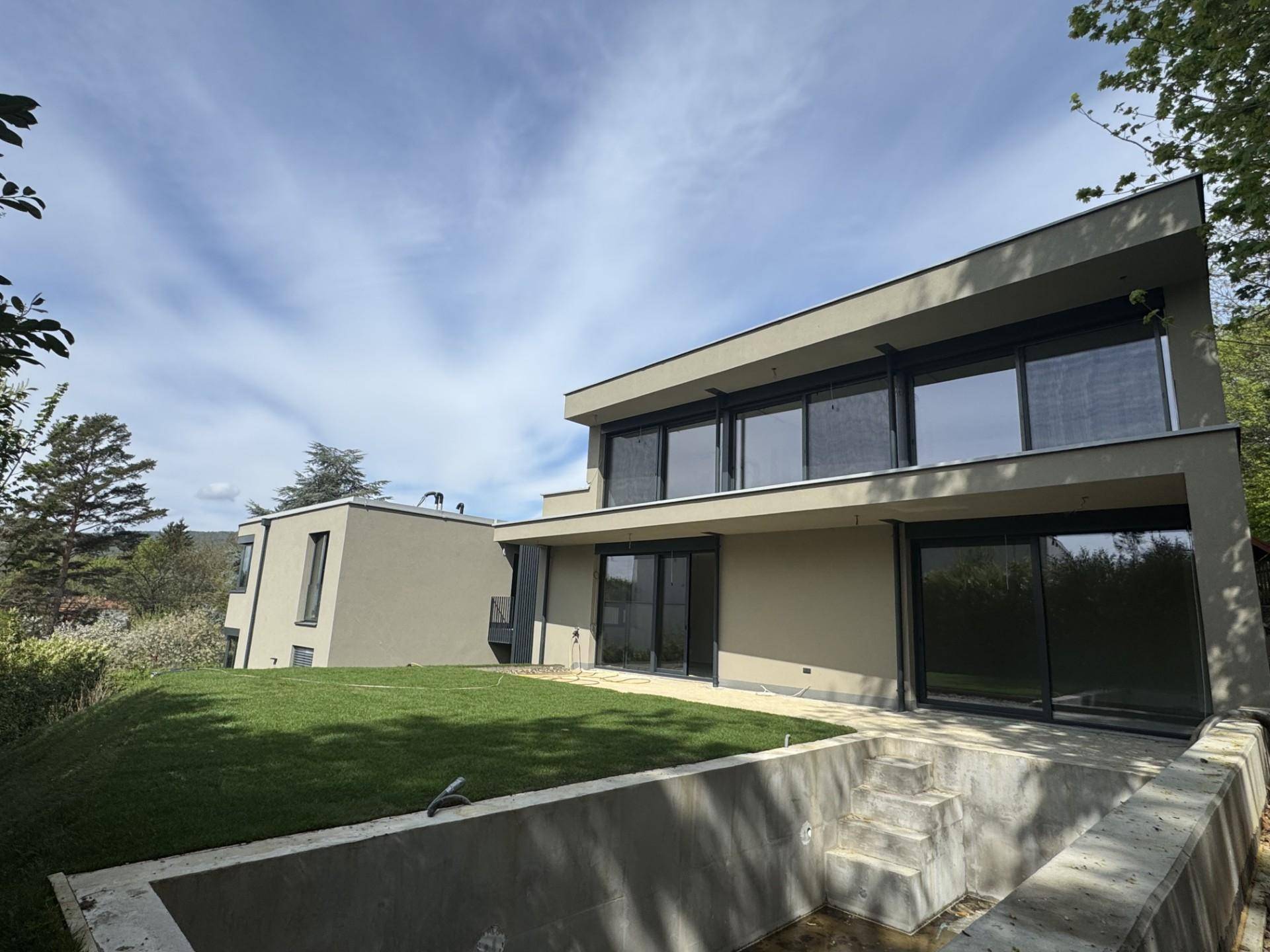 Moderne Architektur der Villa mit Gartenbereich und vorbereitetem Pool oder Terrassenbereich.