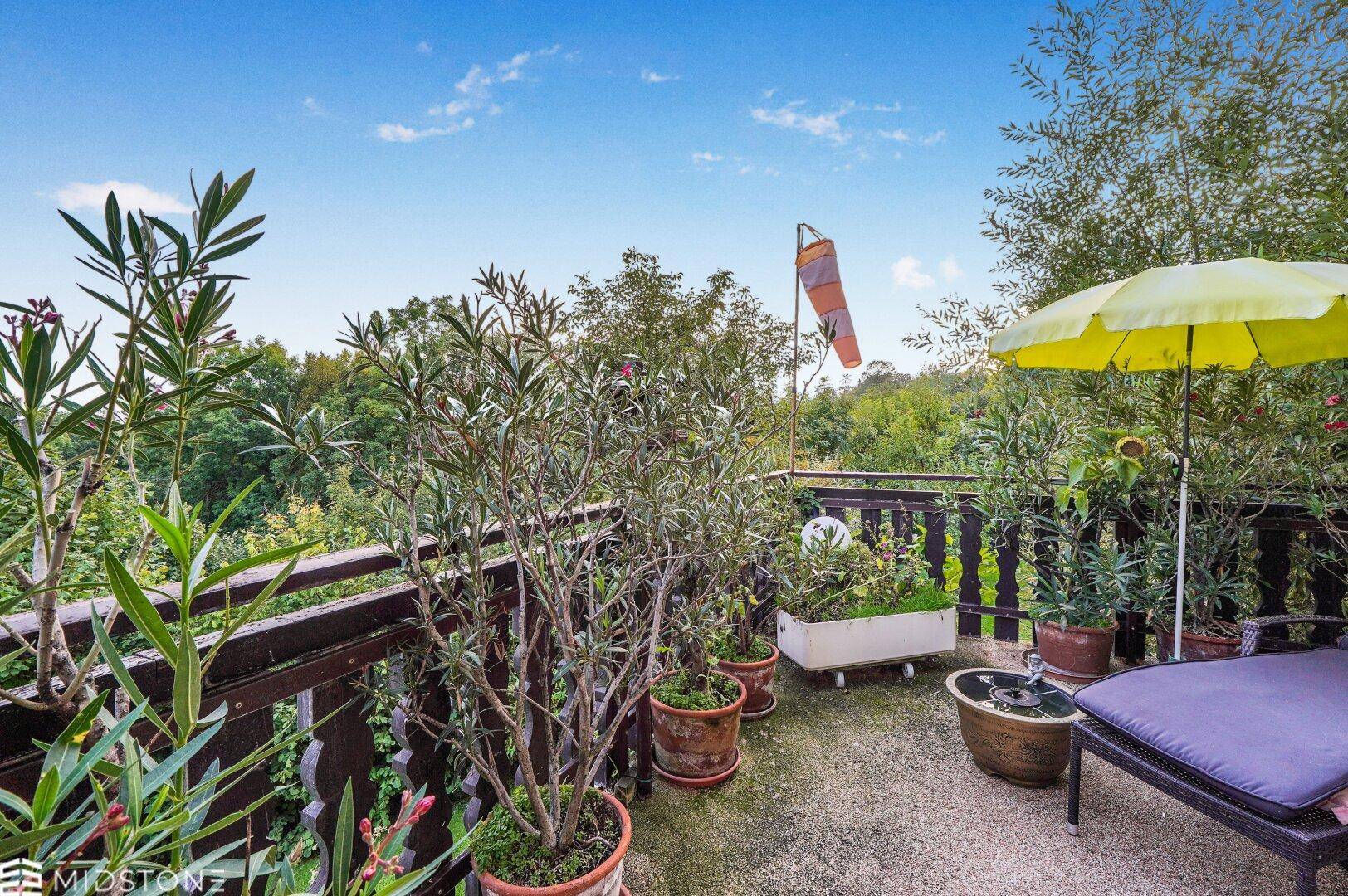 Balkon mit Pflanzen und Sitzgelegenheiten, bietet einen weiten Blick ins Grüne.
