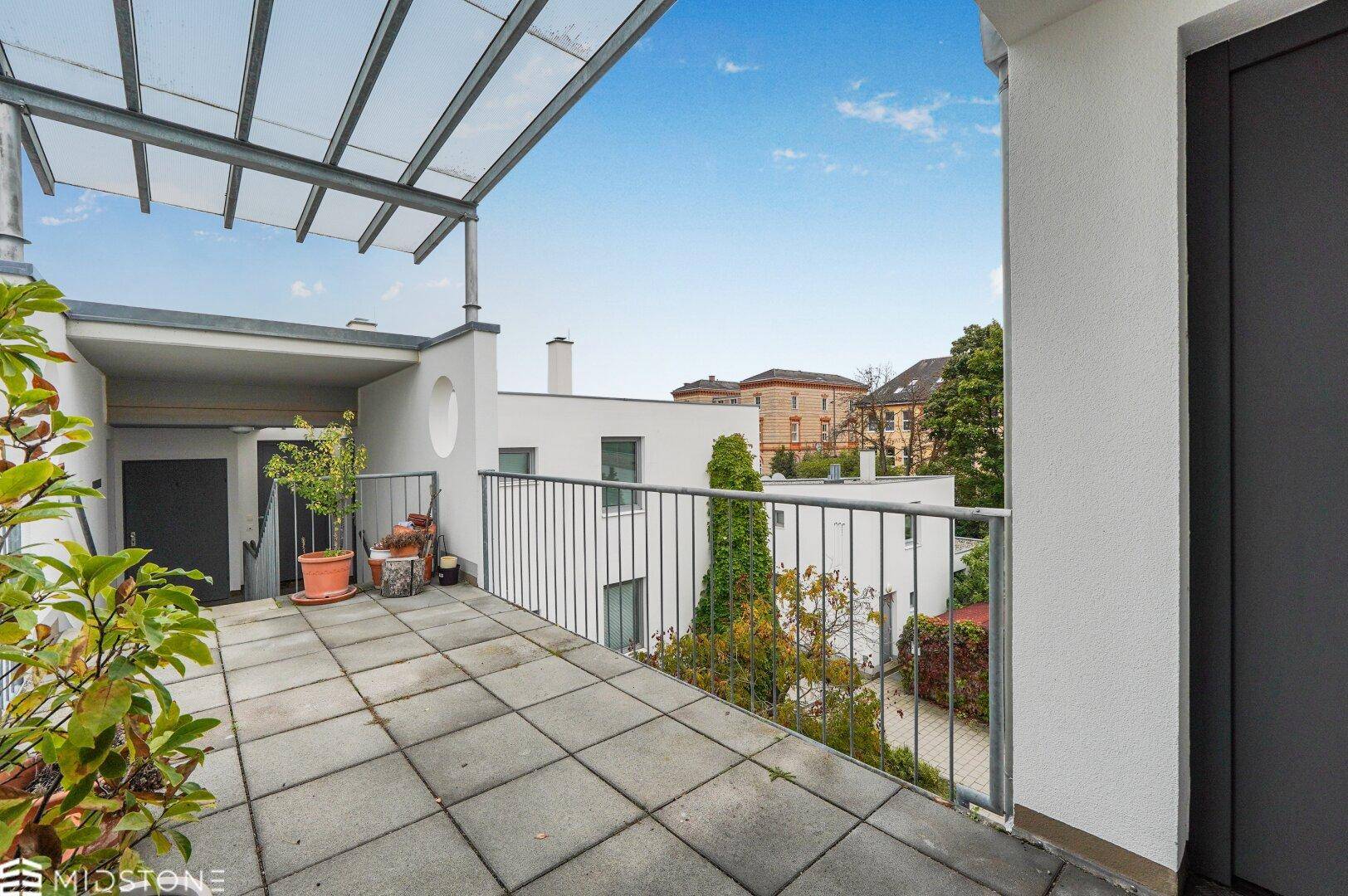 Große Dachterrasse mit Fliesenboden und teilweiser Überdachung, bietet Platz für Entspannung.