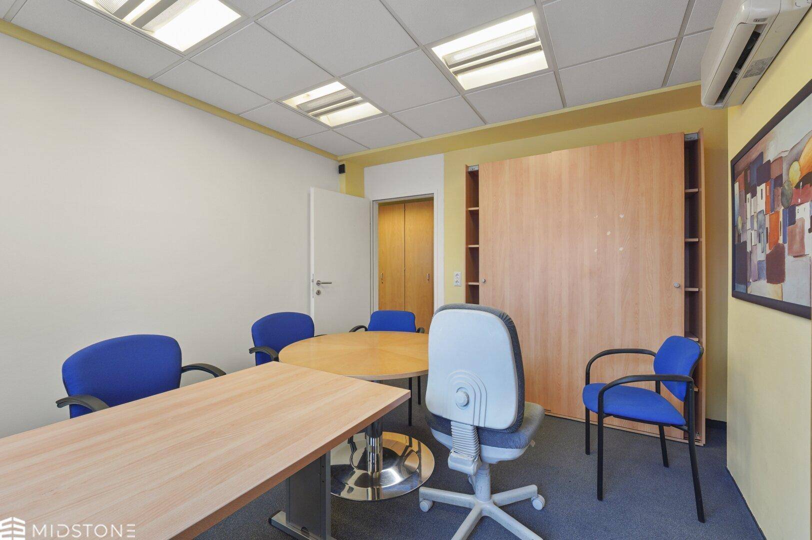 Funktionales Büro mit Einbauschränken und Klimaanlage, ausgestattet für produktive Arbeitsumgebungen.