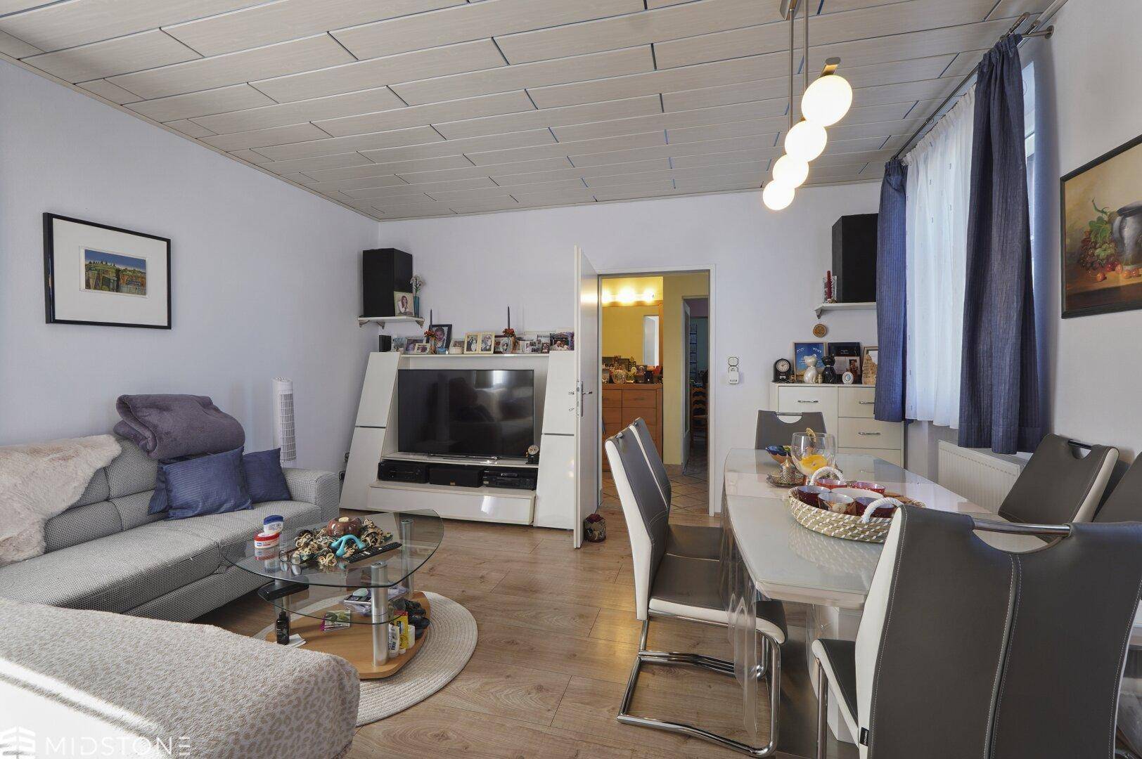 Geräumiger Wohn- und Essbereich mit Holzboden und moderner Einrichtung.
