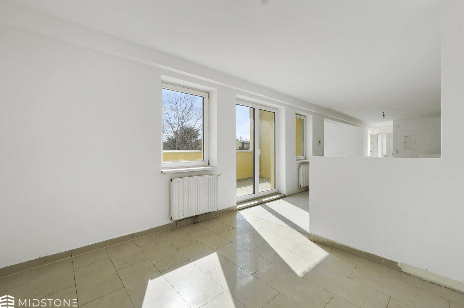Heller, leerer Raum mit Fliesenboden und Balkonzugang, bietet viel Tageslicht und frische Luft.