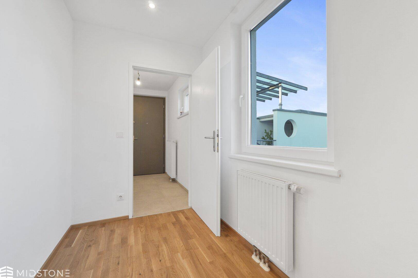 Kleinerer Raum mit Parkettboden und Fenster, ideal als Kinder- oder Arbeitszimmer.