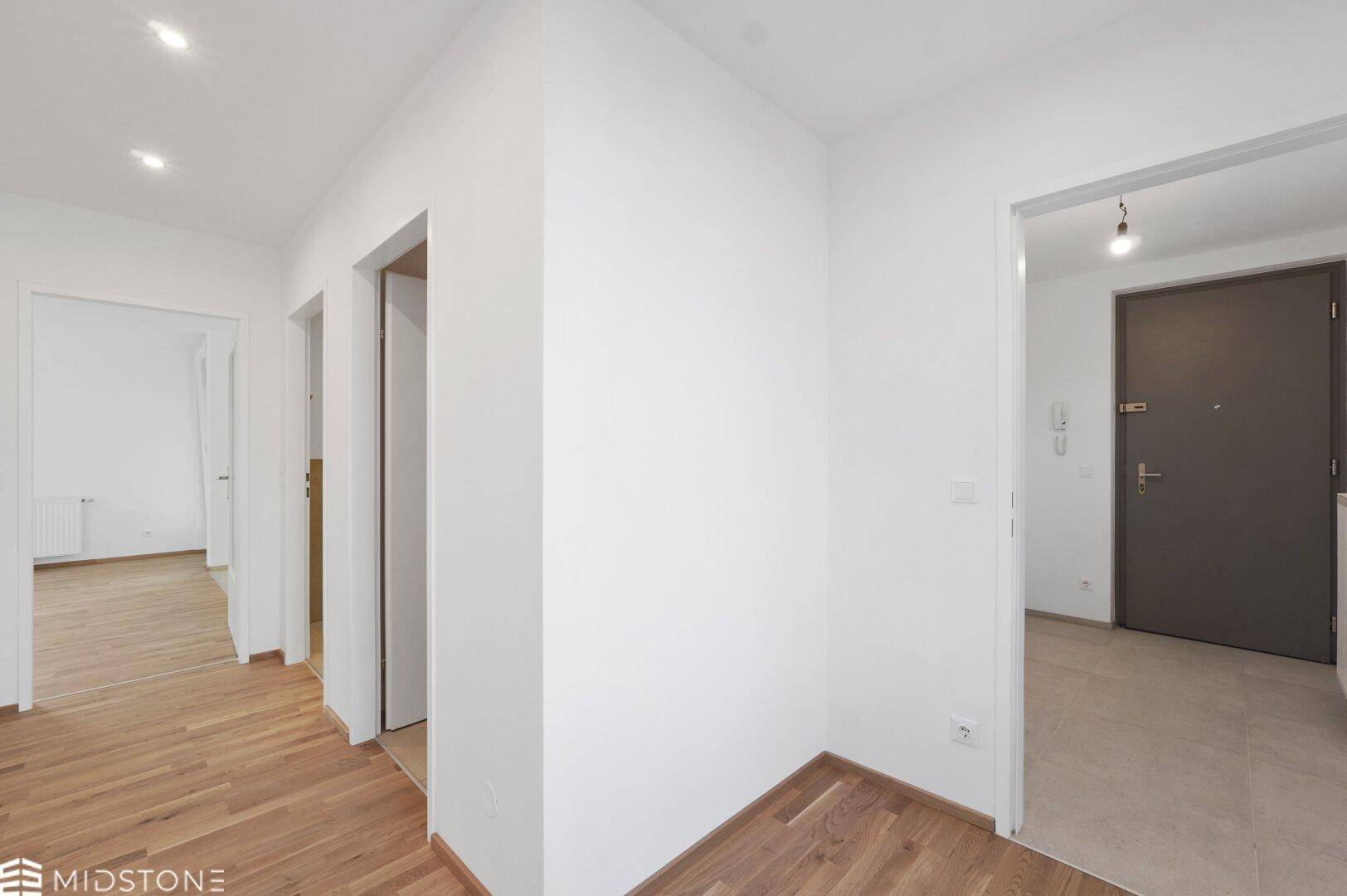Heller Flur mit Parkettboden und Zugang zu verschiedenen Räumen der Wohnung.