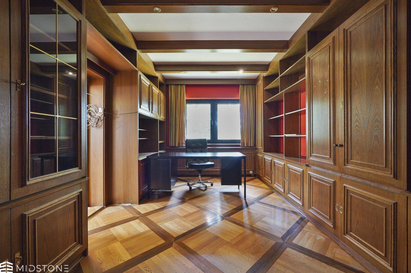 Elegantes Arbeitszimmer mit umfangreichen Holzregalen und Schränken, ideal für eine Bibliothek.