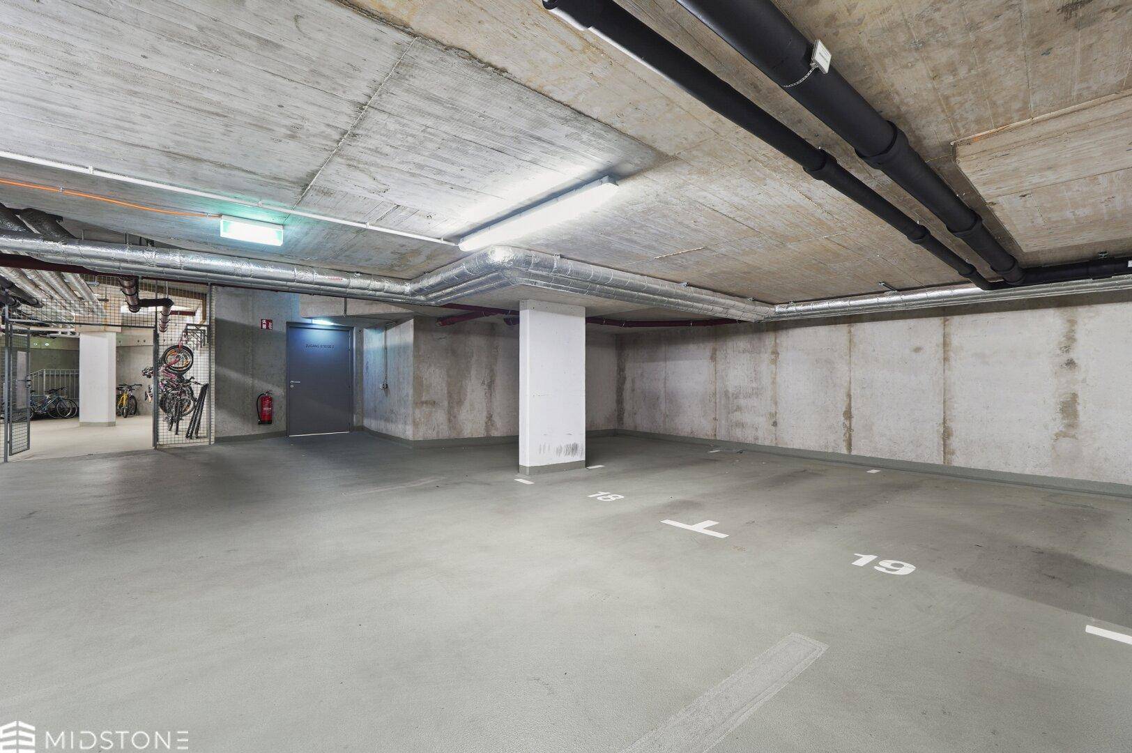 Geräumige Tiefgarage mit markierten Stellplätzen und Fahrradabstellbereich.