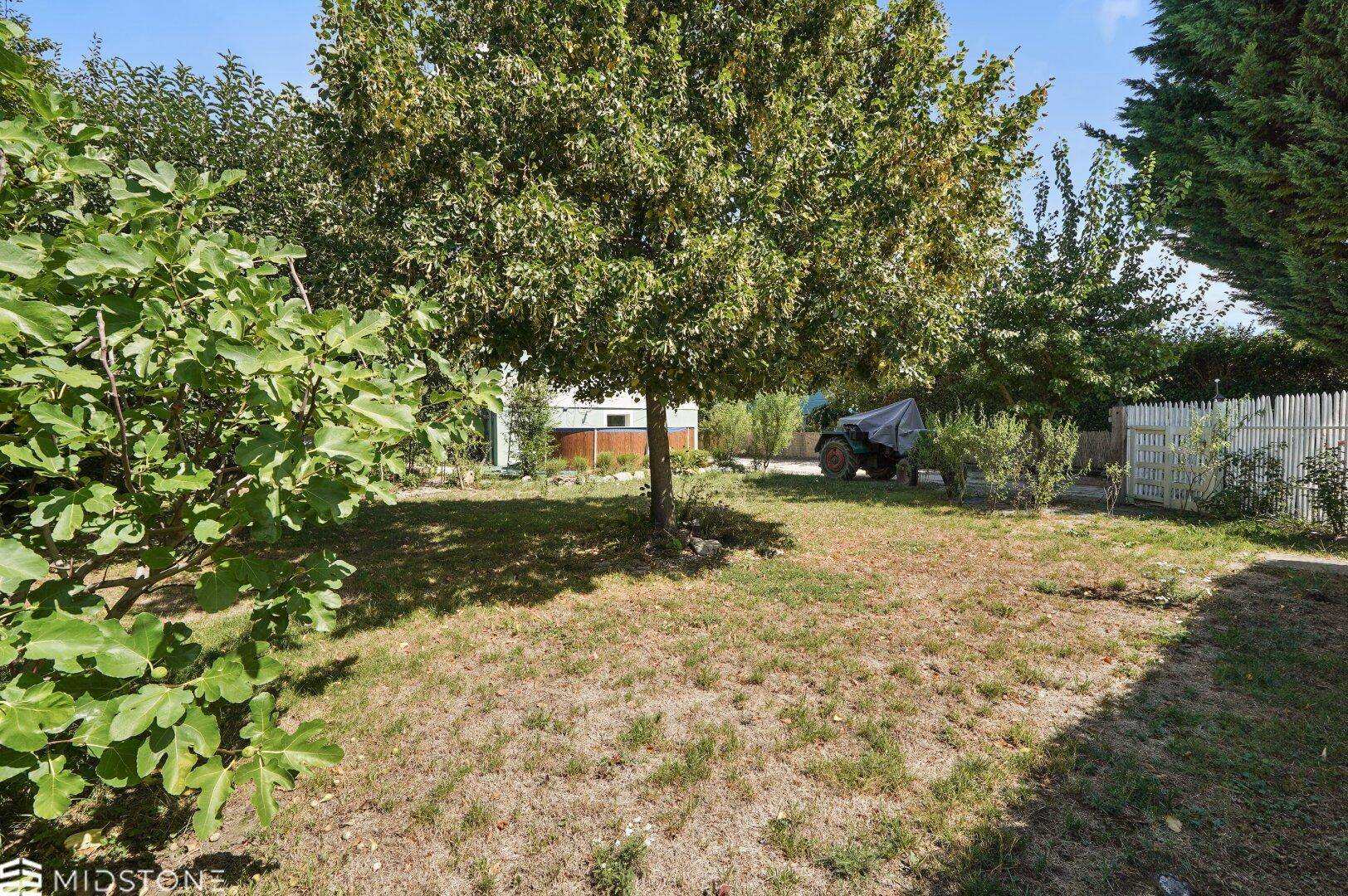 Weitläufiger Garten mit Bäumen und Blick auf das Grundstück und die Umgebung.