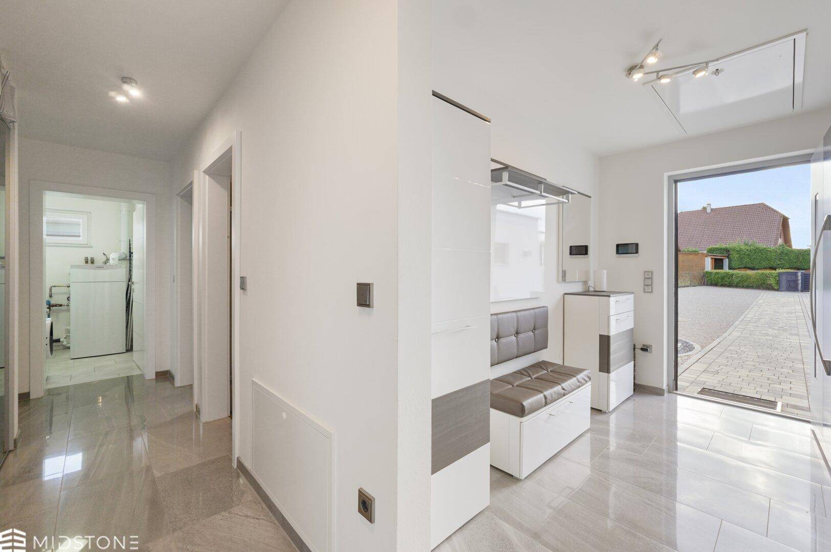Heller Eingangsbereich mit moderner Garderobe und Blick nach draußen.